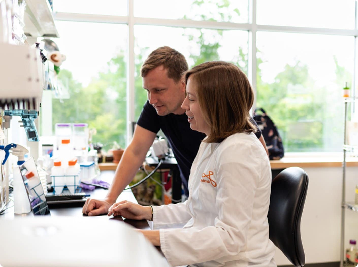 Scientists reviewing antibody discovery data on a lab computer.