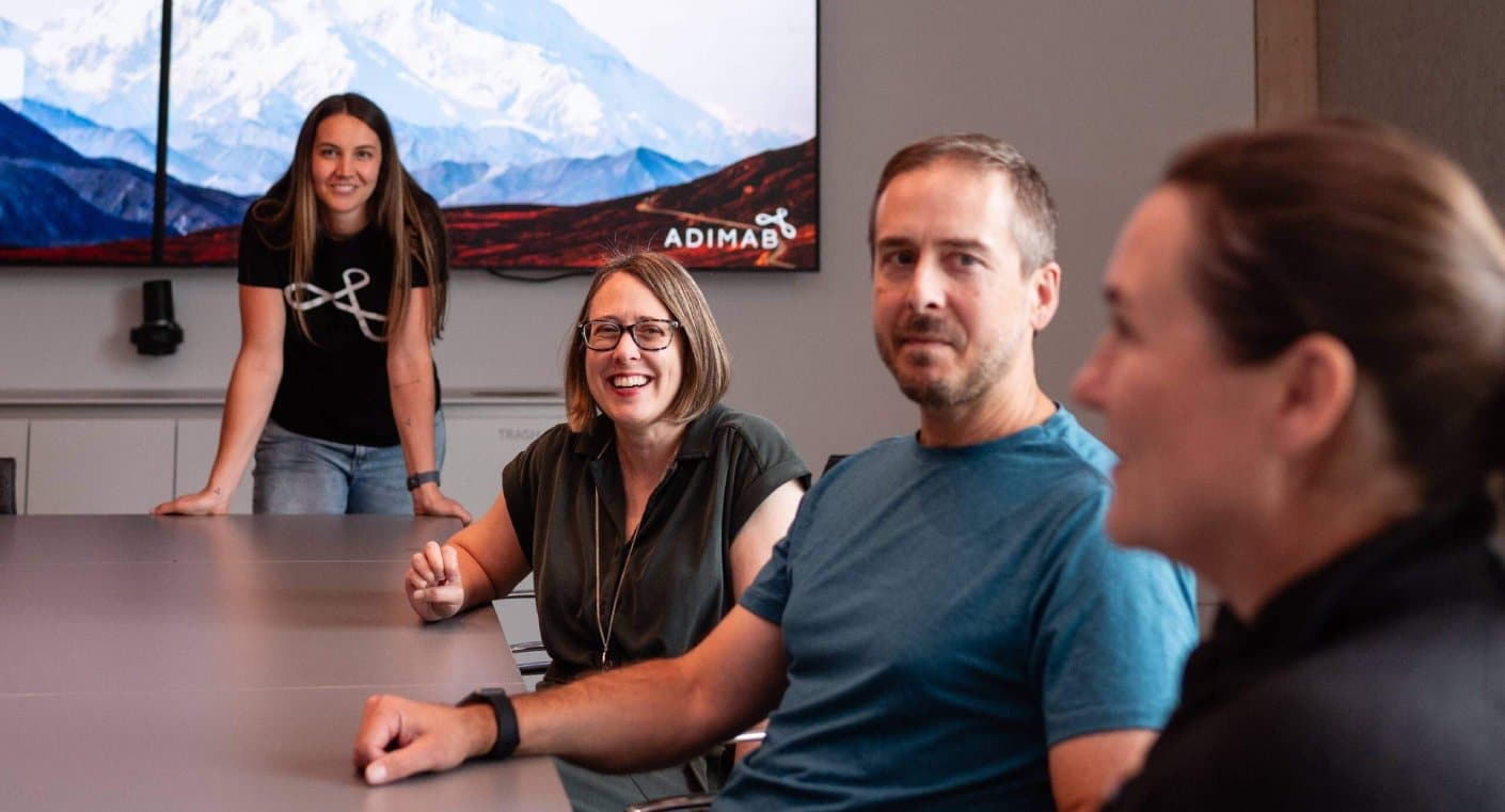 Adimab team members gathered around a conference table during a meeting.