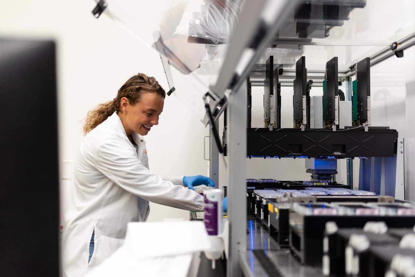 Scientist operating a high-throughput automated system in a laboratory setting.